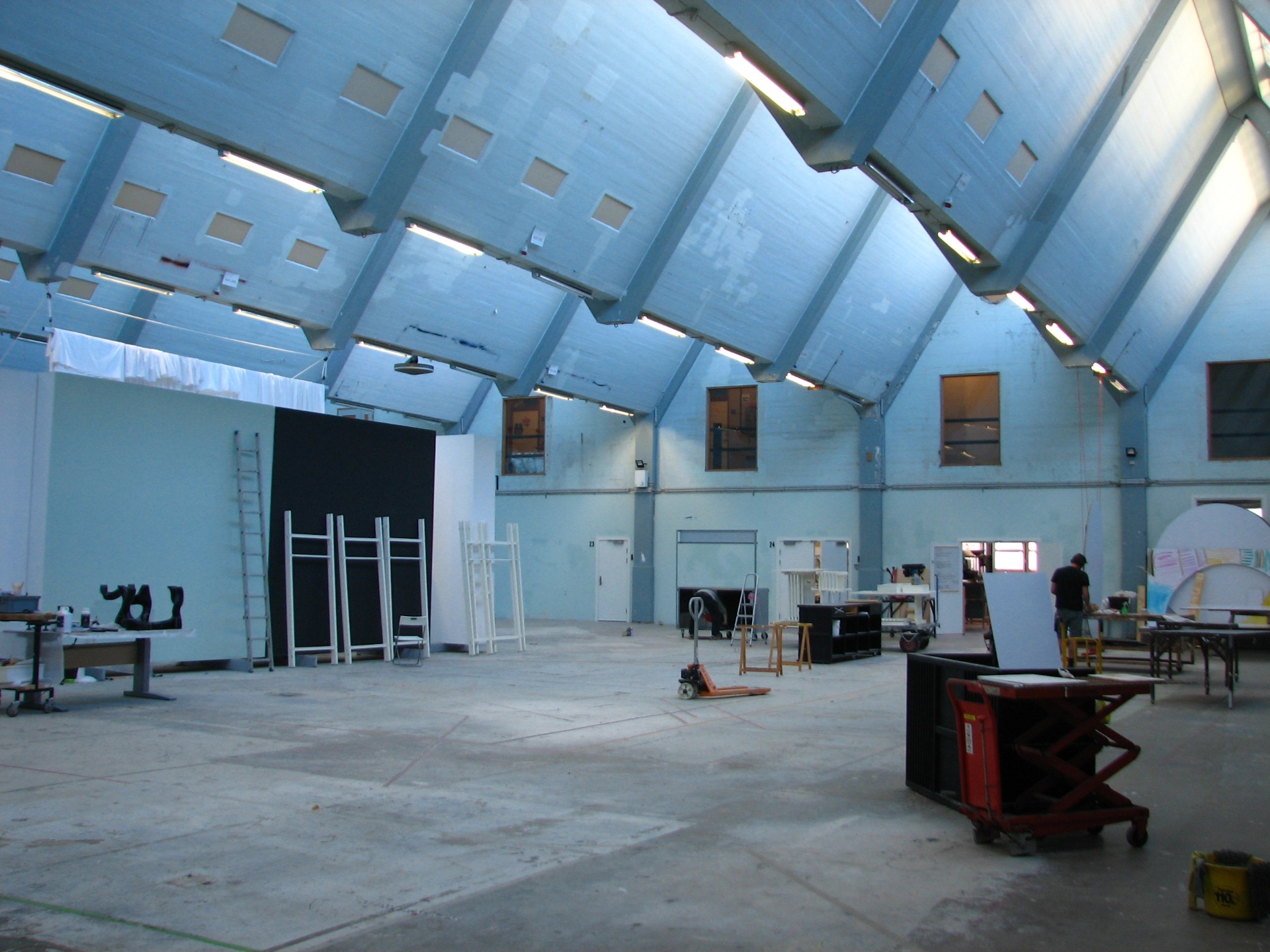Interior of FABRIKKEN's main concrete hall with blue painted trusses